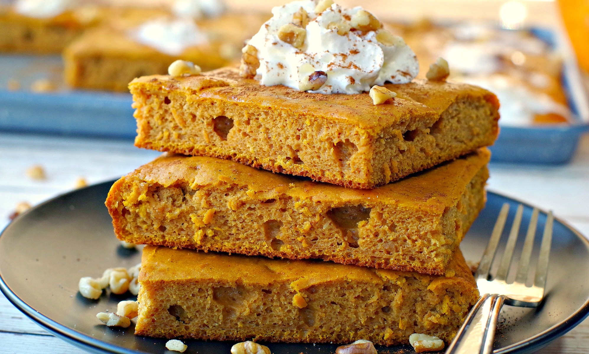 stack of 3 sheet pan pumpkin pie pancakes on black plate