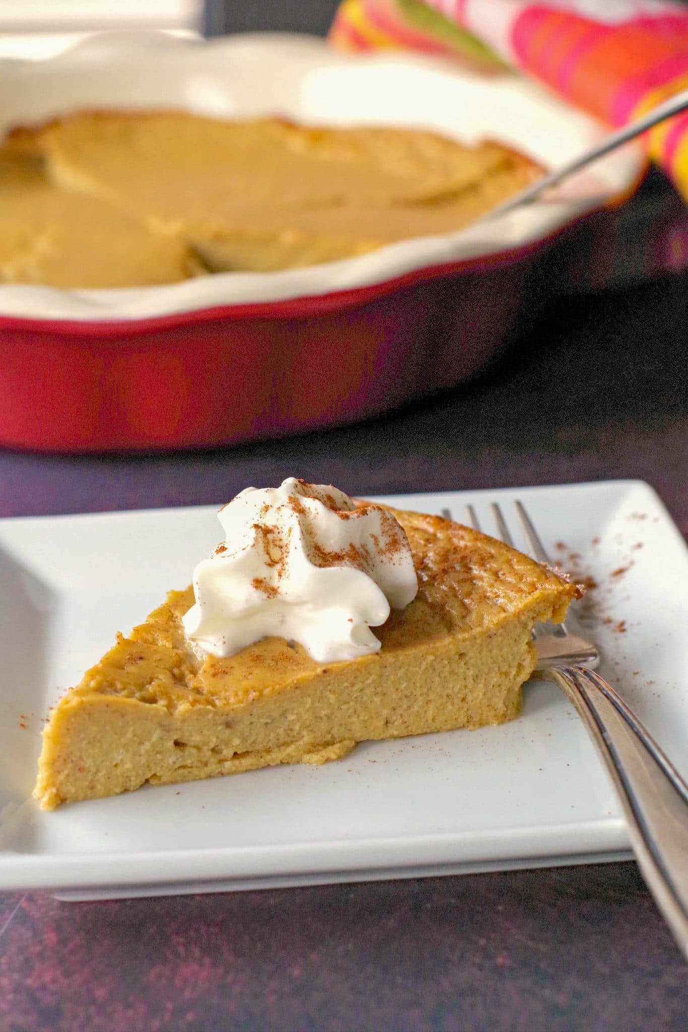 WW no crust pumpkin pie on a white plate with fork and whole pie in background