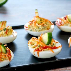 banh mi devilled eggs on a narrow black serving platter