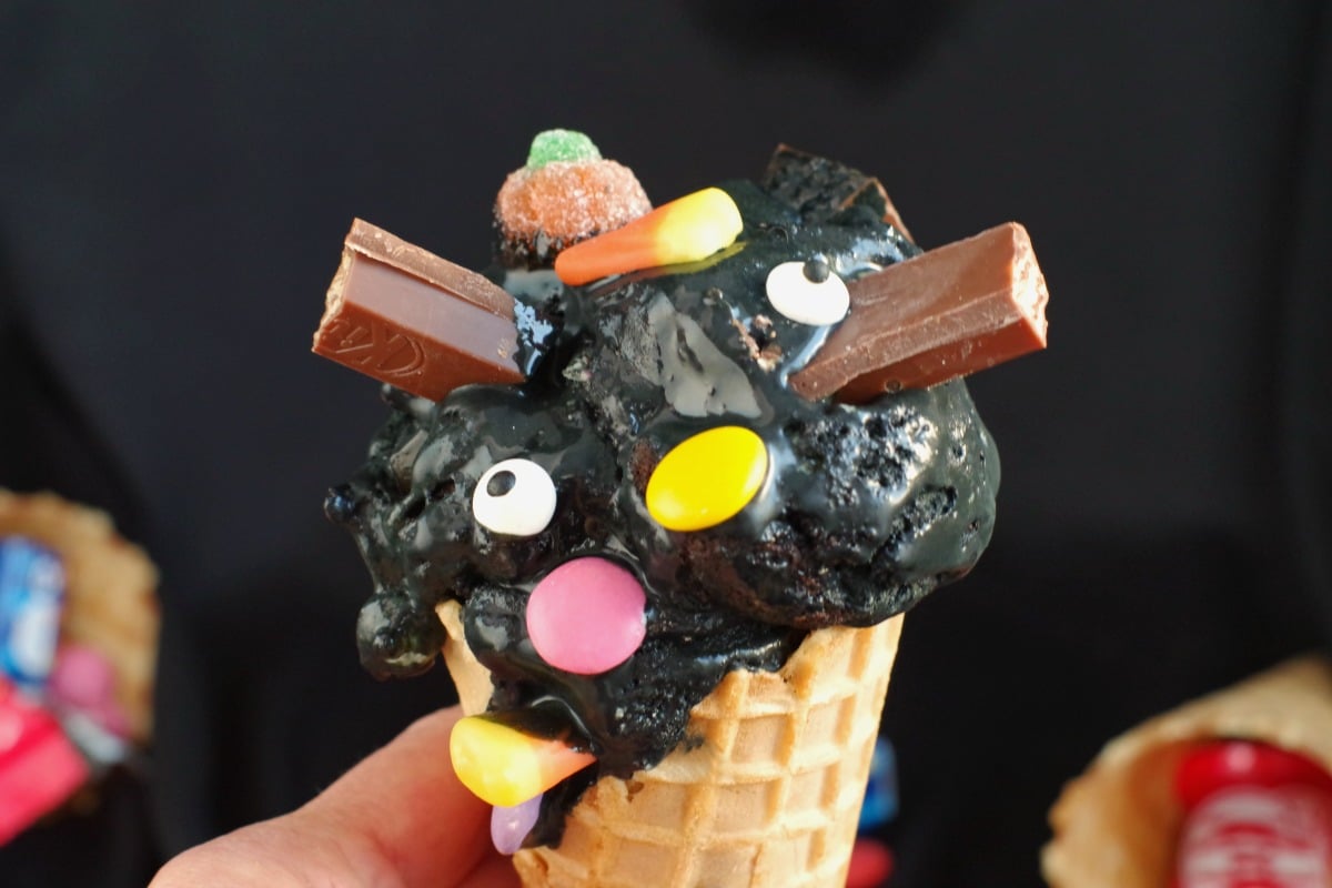 Boo batter ice cream in a cone being held in a hand