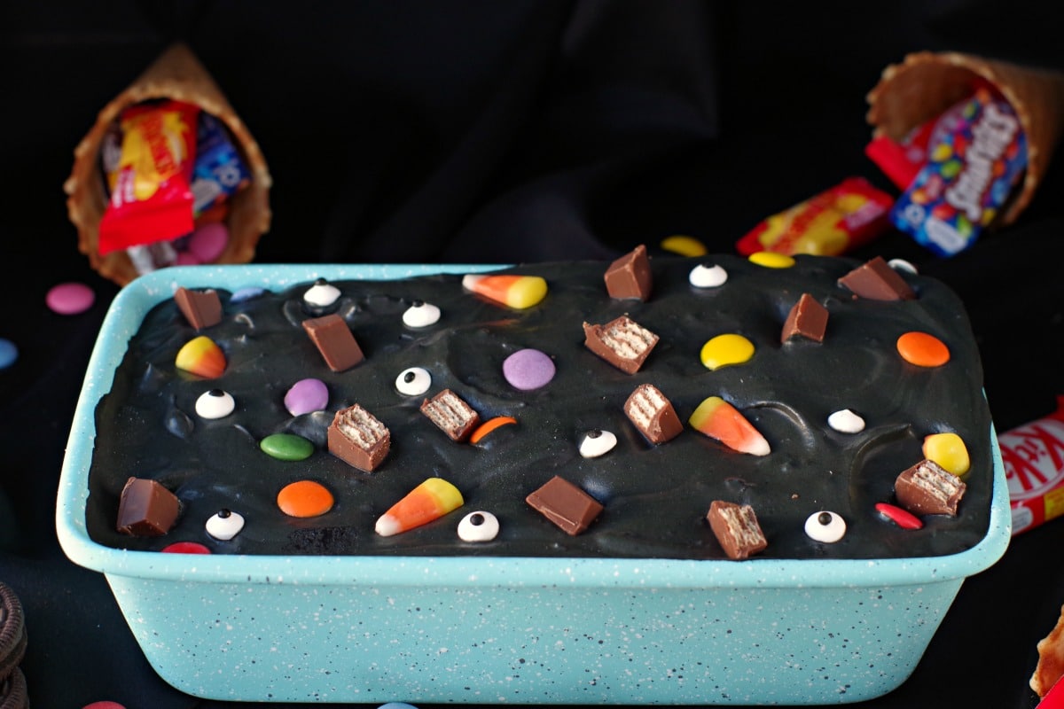 Halloween Boo Batter in a blue speckled loaf pan with candy and cones in the background
