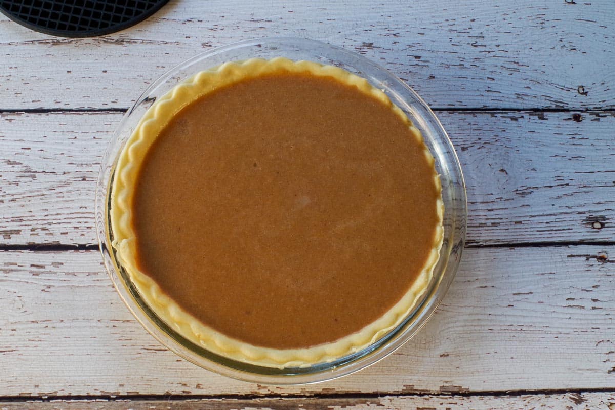 Sweet Potato Pie filling poured into a deep dish pie crust.