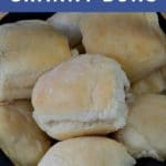 Pinterest pin with white text on blue background on top and bottom and photo of dinner buns piled in wicker basket on top of black napkin