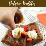 Pinterest pin with text at the top and bottom and a photo of chocolate belgian waffles with syrup being poured over them