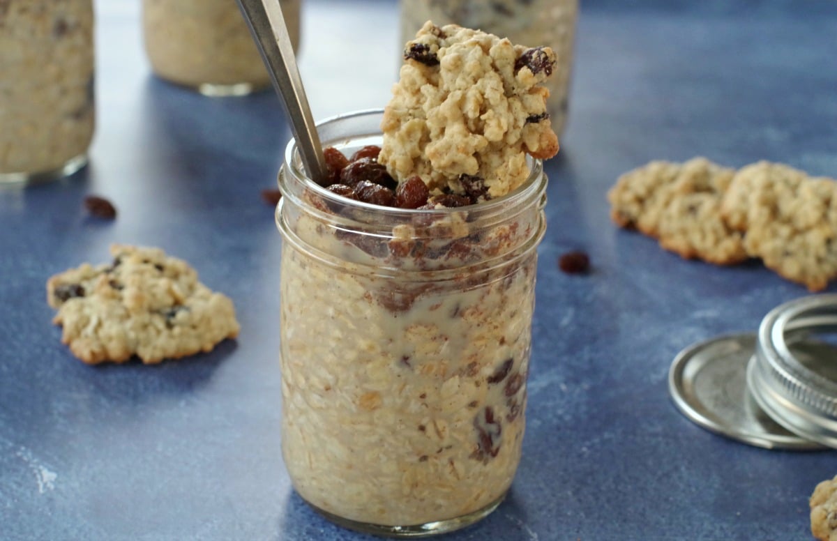 raisin cookie oatmeal in a jar with cookie on top on blue background with raisin oatmeal cookies around