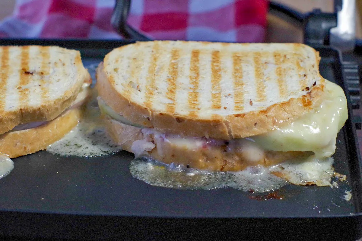Turkey Brie Cranberry Sandwich cooking on a Panini press