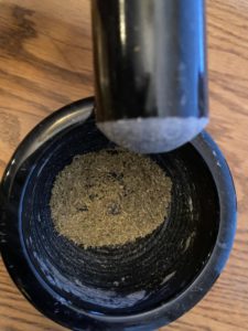 fennel seed ground with pestle and mortar