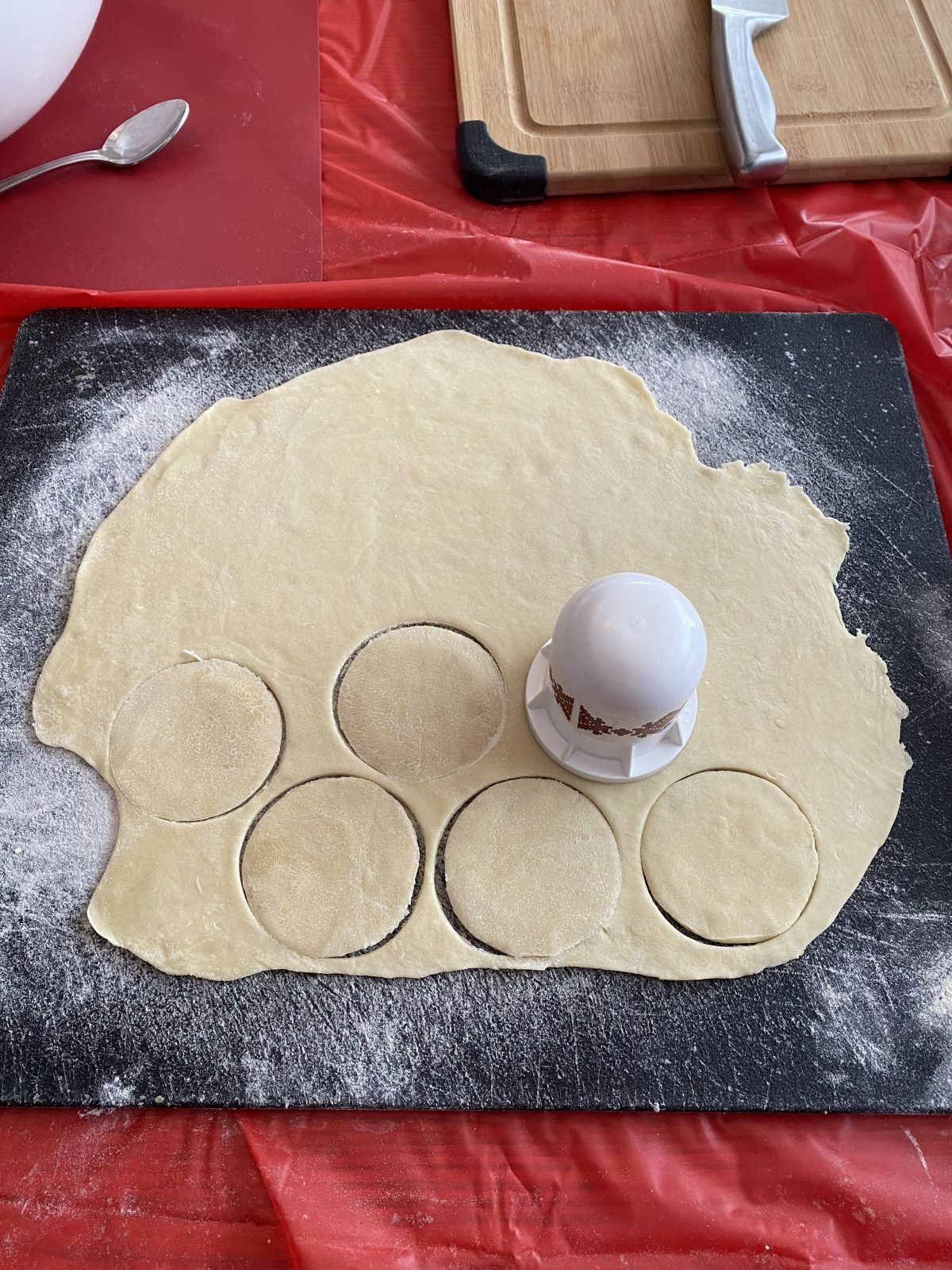 dough being cut into circle with perogy cutter