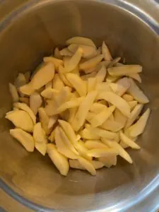 apples being tossed in a bowl with