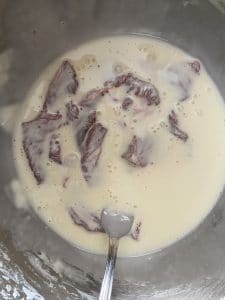 beef being coated in batter