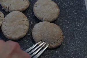 fork pressing into pita bread to make pie like imprint