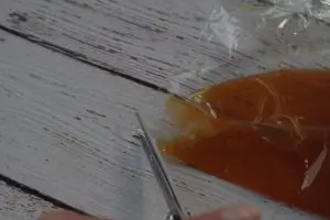 ziplock bag with caramel sundae sauce, with the corner being cut with scissors