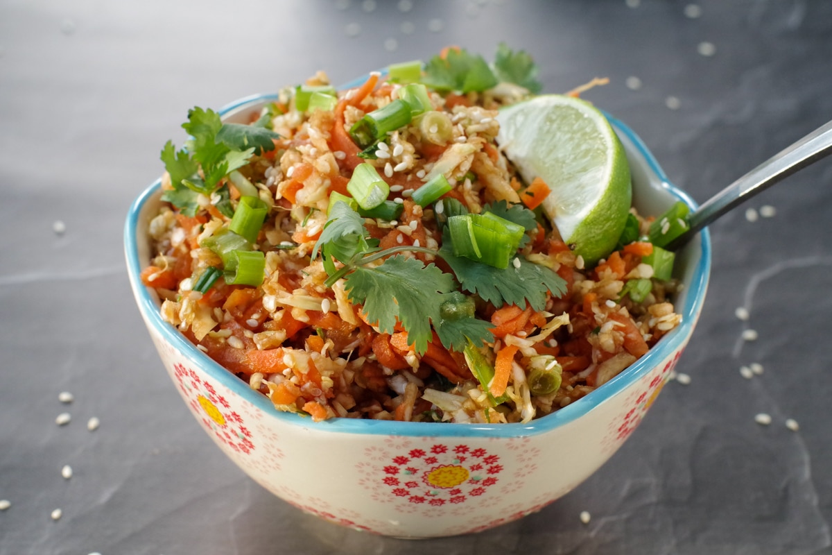 bowl of skinny coleslaw with limes in the background