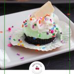 Pinterest pin with green and black text on white background on bottom and photo of no churn ice cream cupcake on a white plate