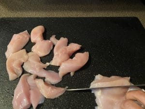 chicken being cut into stips