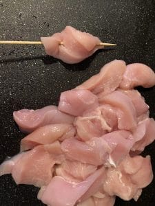 chicken strips being added to skewer
