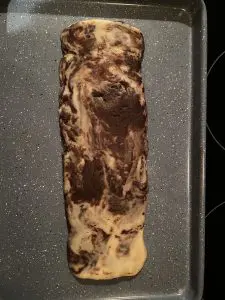 flattened biscotti log on greased baking sheet