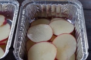 sliced potatoes in an aluminum foil container