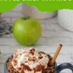 apple crisp in a mug with a cinnamon stick and an apple in the backgrouns