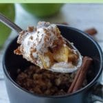 Pinterest pin with black text on green background on top and bottom and photo ofspoon with apple crisp being held up above a black mug apple crisp with 2 green apples and cinnamon sticks in the background