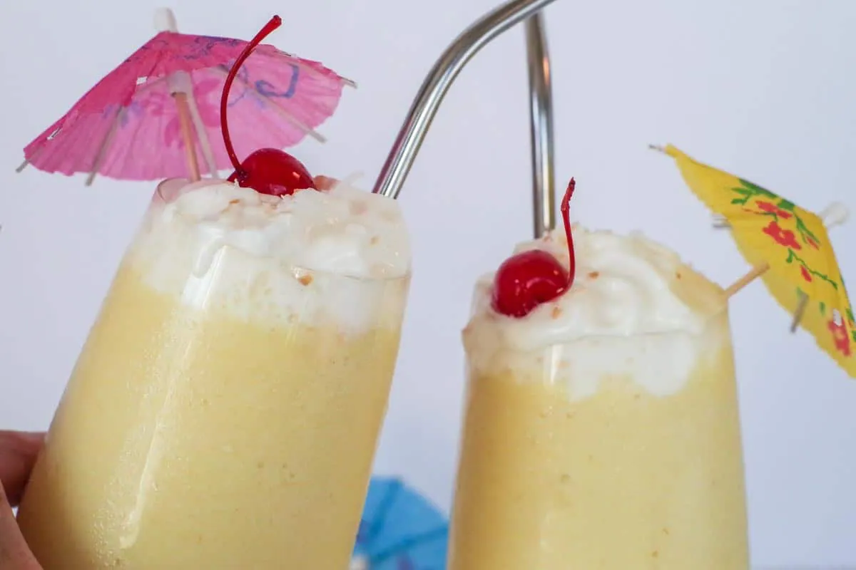 2 healthy Pina Colada glasses clinking together