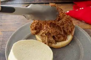 meat being placed on bun
