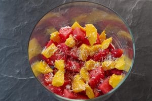 chunks of watermelon, mango and strawberries, sprinkled with toasted coconut in the bottom of a trifle bowl
