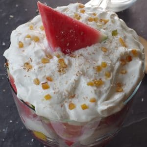 watermelon trifle topped with yogurt, watermelon triangle wedge, toasted coconut and candied citrus peel