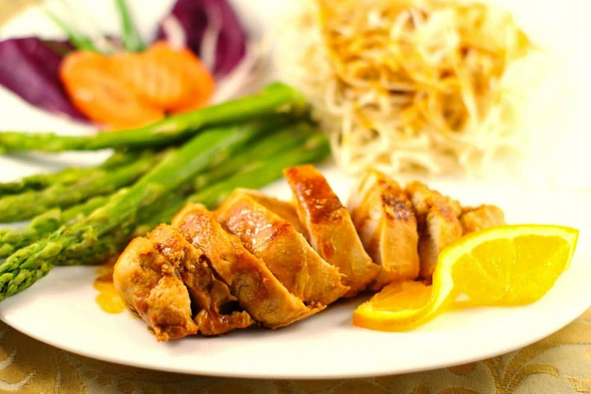 Hoisin sauce with chicken on white plate with asparagus and chow mein noodles