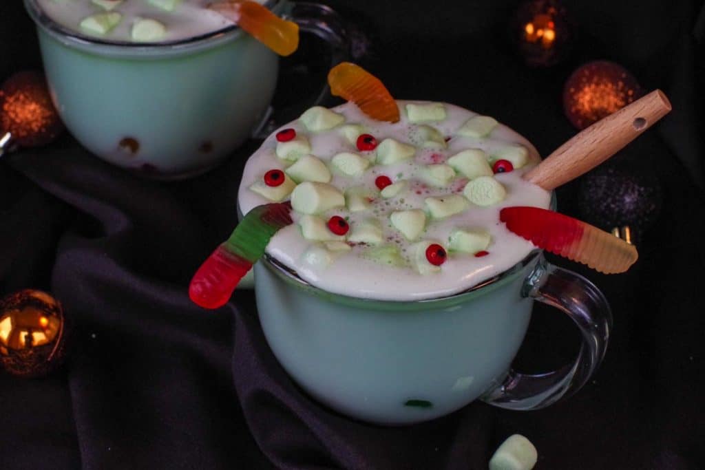 Halloween hot chocolate in a clear mug with a black background