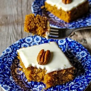 pumpkin bar on a blue flowered plate with piece being held on a fork, with another piece in the background