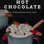 pinterest pin with with white text on black background and photo of Halloween hot chocolate in a clear mug with a black background