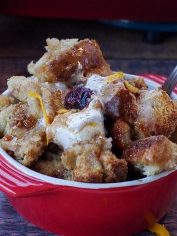 cranberry toffee bread pudding in a red bowl with a spoon