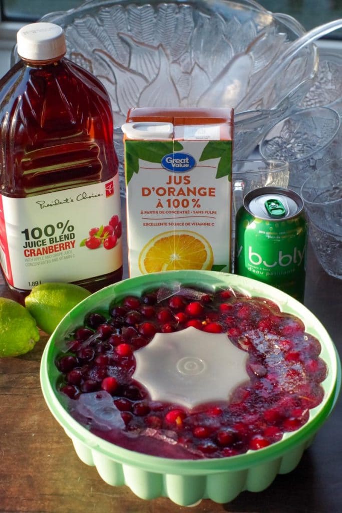 ingredients for Cranberry Christmas morning punch with punch ice ring in front and punch bowl in background