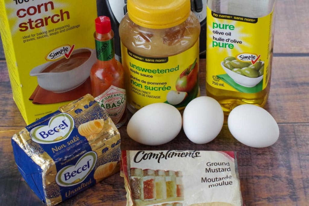 eggs, butter, applesauce, olive oil, dry mustard, cornstarch, Tabasco sauce on wooden surface