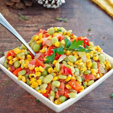 healthy corn succostash in a white bowl on brown wooden surface