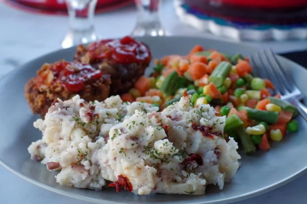 chipotle mashed potatoes on a plate with vegetables and meatloaf