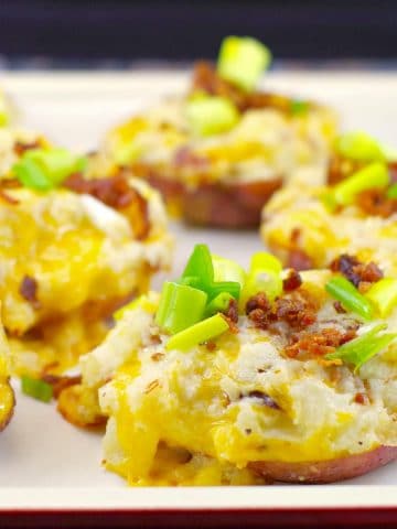 twice baked potatoes on an off-white baking sheet
