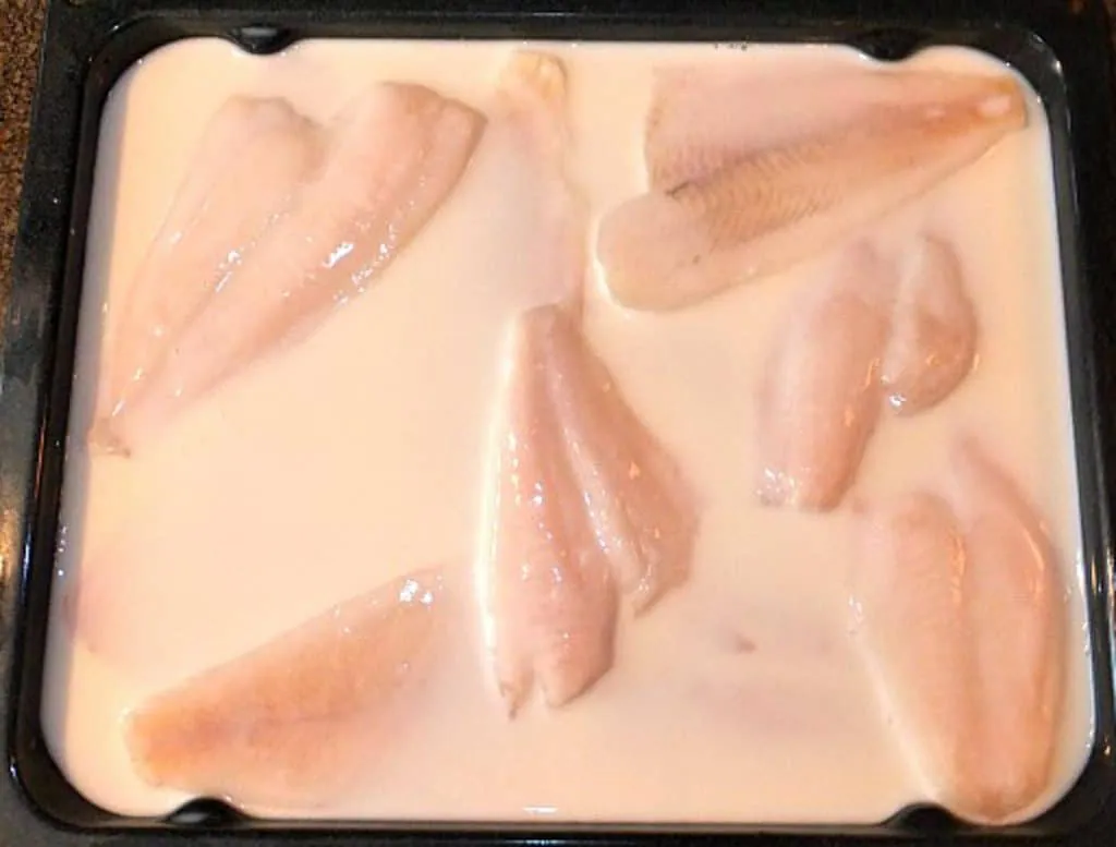 fish defrosting in milk in a pan