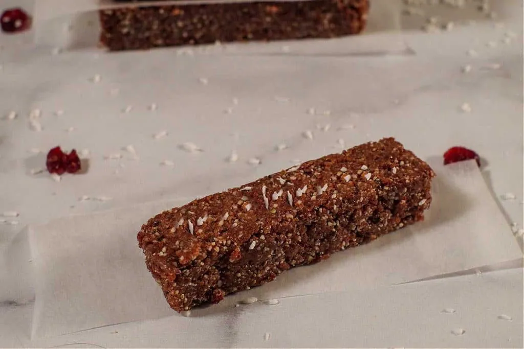 No bake energy bar on a counter with coconut scattered around