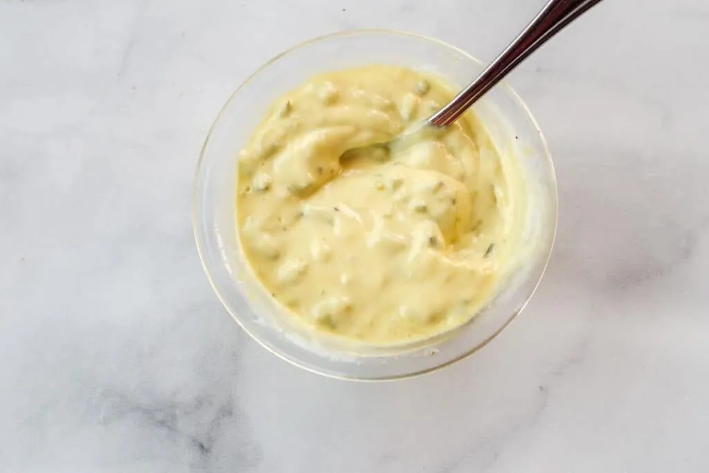 healthy tartar sauce in a glass bowl with spoon, on counter top