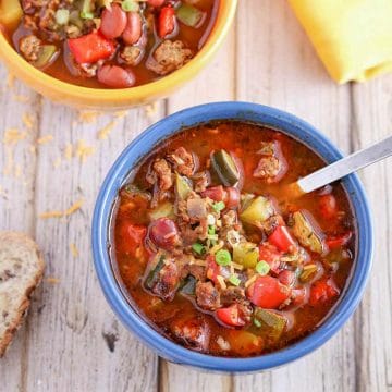 Indian Spiced Turkey Chili in a blue bowl with spoon and yellow bowl of chili in the background