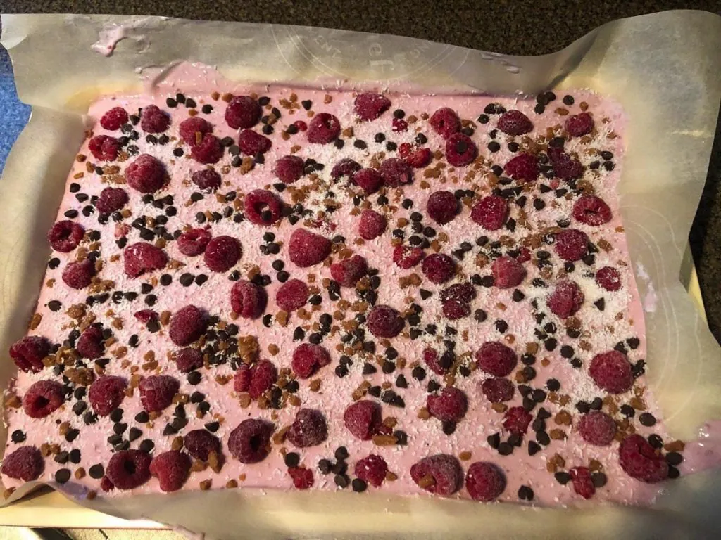 raspberry yogurt with toppings on a parchment covered baking sheet
