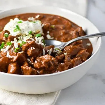 Texas chili in a white bowl with spoon