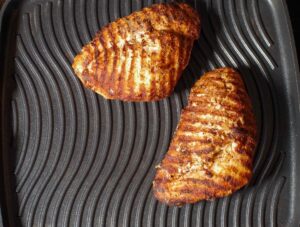 2 pieces of grilled chicken on stove top grill