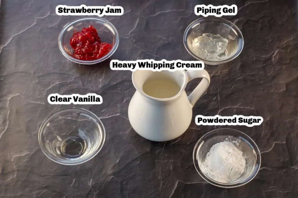 photo of labelled ingredients needed for strawberry whipped cream frosting (on a black granite surface)