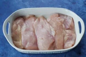 raw chicken breast in a white casserole dish