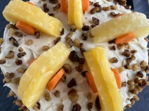 top of cake decorated with pineapple and carrots