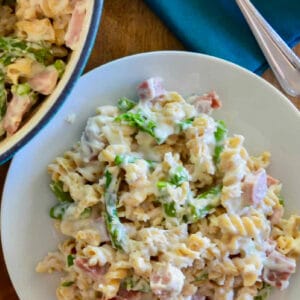 cheesy ham and asparagus pasta in a white bowl