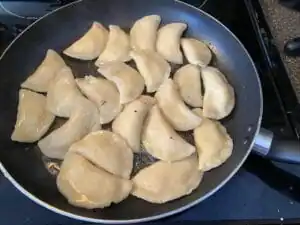 perogies being fried in a large skillet